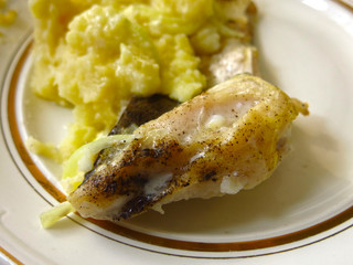 baked fish with onions and potatoes on a plate