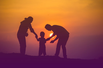 Happy family, father, mother, son in nature, sunset