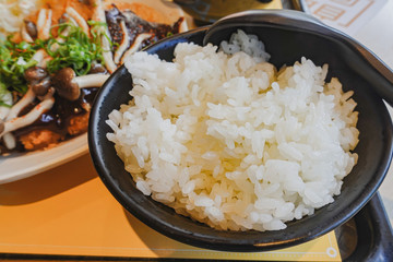 Japan rice in a black bowl with spoon