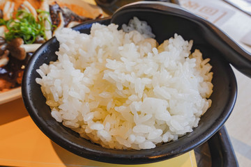 Japan rice in a black bowl with spoon