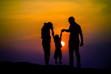 Fototapeta na wymiar Happy family, father, mother, son in nature, sunset