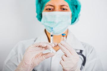 Vaccine bottle and syringe in a doctors hands close-up.  COVID-19/ Coronavirus concept. 