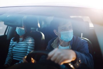 Fototapeta na wymiar Boy and girl wear protective sterile medical mask in the car. The concept of preventing the spread of the epidemic and treating coronavirus, pandemic in quarantine city. Covid -19.