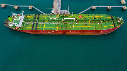 Fototapeta na wymiar Aerial view tanker ship vessel unloading at port, Business import export oil and gas petrochemical tanker ship cargo transportation oil from dock refinery, Loading arm oil and gas offshore platform.
