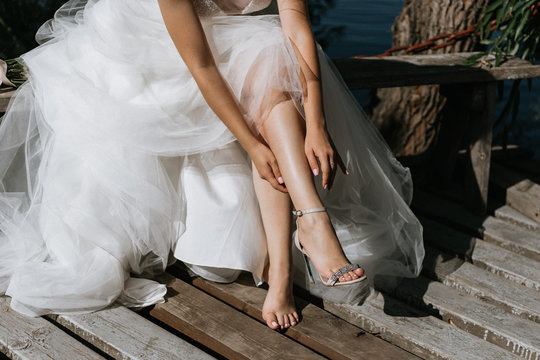 bride puts on wedding shoes