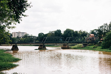 Iron bridge with red river in film style at Chiang Mai