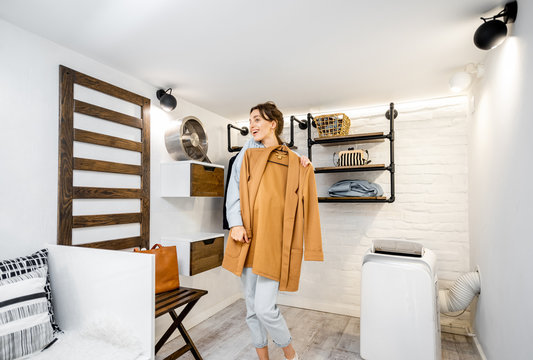 Young Woman Trying A Jacket, Choosing Clothes To Wear In The Modern Small Wardrobe At Home