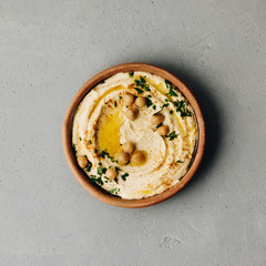 Obraz na płótnie Canvas Large bowl of homemade hummus garnished with chickpeas, red sweet pepper, parsley and olive oil