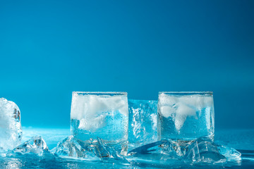 Glass of cold water with ice on a blue background	