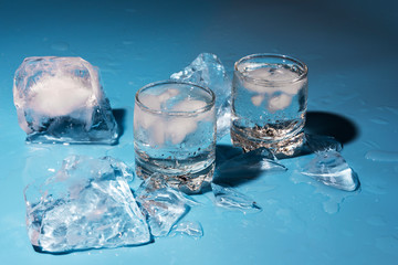 Glass of cold water with ice on a blue background	