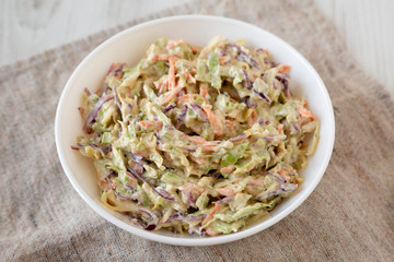 Homemade Creamy Broccoli Slaw in a white bowl, side view. Close-up.