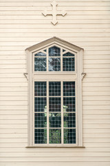 Large window on a pale wooden church wall
