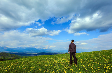 man on the meadow field with blue sky clouds