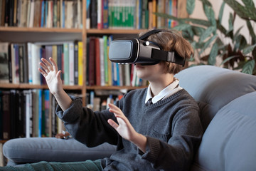 girl uses a virtual reality glasses vr mask , young girl uses virtual reality glasses online education