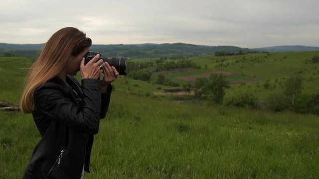 Girl taking pictures in mountainous terrain