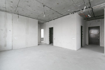 interior of a new apartment without finishing in gray tones with electrical wiring