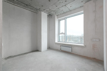 Obraz premium interior of a new apartment without finishing in gray tones with electrical wiring
