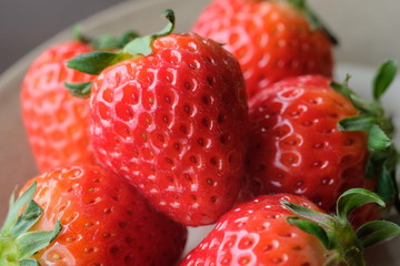 お皿の上の新鮮いちご。Fresh strawberries with leaf on a old wooden table