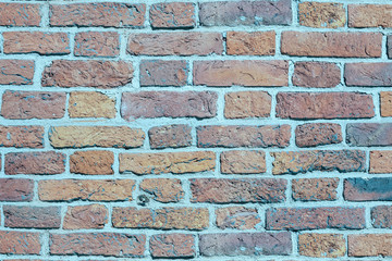 Old brick wall of weathered brick of different colors as a background