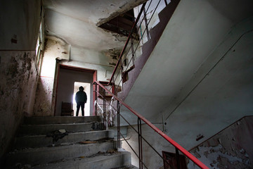 Fototapeta premium Dramatic portrait of a man wearing a gas mask in a ruined building.
