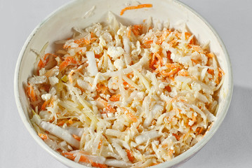 Salad of fresh cabbage, carrots and cheese. Homemade salad in a bowl.