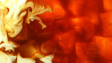 Detail of milk mixing in ice coffee drink