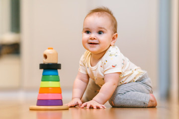 A nine-month-old baby crawls on the floor