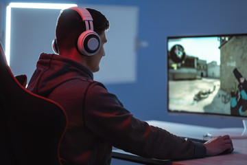 The young gamer playing online video game on his personal computer © Artem