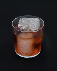 A glass of whiskey with ice in case of glass