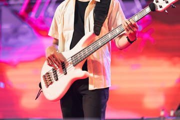 Obraz na płótnie Canvas Guitarist bass showing on concert stage. Enterment and music concept.