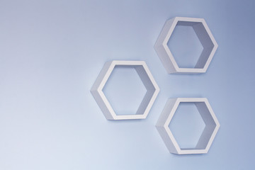 Hexagon wooden white shelf on a blue wall