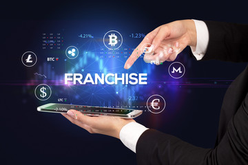 Close-up of a touchscreen with FRANCHISE inscription, business opportunity concept