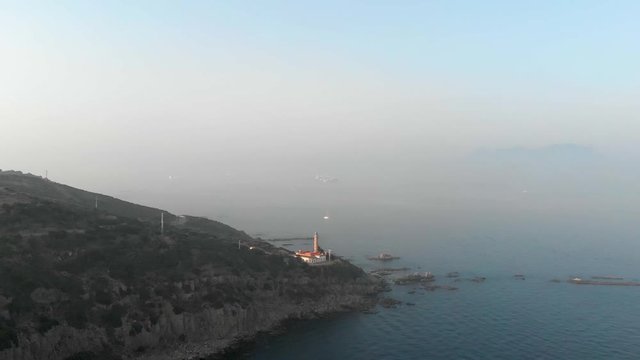 Drone flies towards the lighthouse in Punta Carnero, Spain.