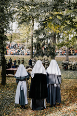 Fototapeta premium 13.10.2019 Vinnitsa, Ukraine: Three Red Cross Workers Standing Opposite Battlefield During Military Reconstruction of Guerrilla Battle with Red Army