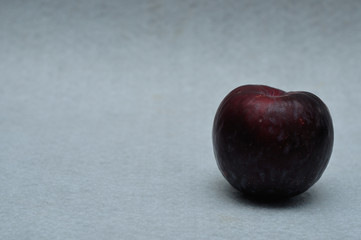 A ripe plum on a white background