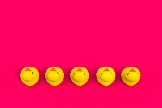 Close up of baby rubber ducks isolated. Bath toys on a pink background. Top view with copy space. Summer wallpaper. 3d rendering.