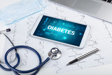Tablet pc and medical stuff with DIABETES inscription, prevention concept