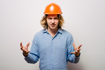 A portrait of an angry male construction worker wearing a safety gear