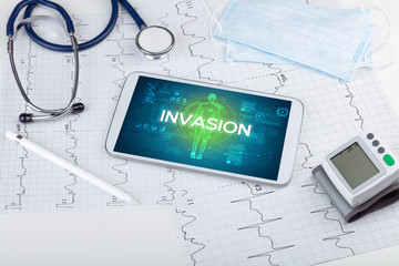 Tablet pc and doctor tools with INVASION inscription, coronavirus concept