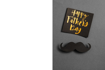 Horizontsl images of card with phrase happy father's day, retro stylish black paper photo booth props moustaches on grey and white background. Holiday concept.