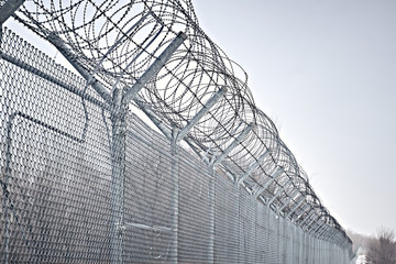 Border fence with barbed wire. Closing for quarantine. Maximum Security Detention Facility.