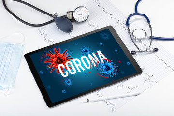 Tablet pc and doctor tools on white surface with CORONA inscription, pandemic concept