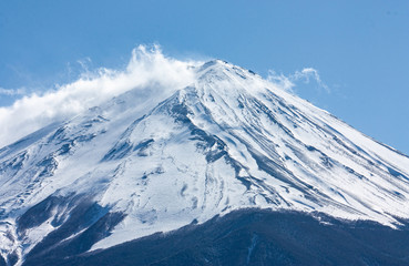 A closeup of the peak of the highest mountain in Japan, Mt. Fuji or Fujisan, in clouds at the beginning of spring