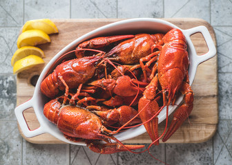 Red boiled crayfish with lemon on a cutting board.