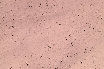 The pink concrete wall. The wall is textured.