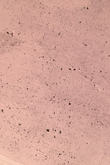 The pink concrete wall. The wall is textured.