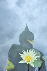 Obraz premium A superimposed or double exposures of Buddha image standing peacefully, sky and a white lotus in a pond. Lots of meaningful of enlightenment and intuition with mindfulness.