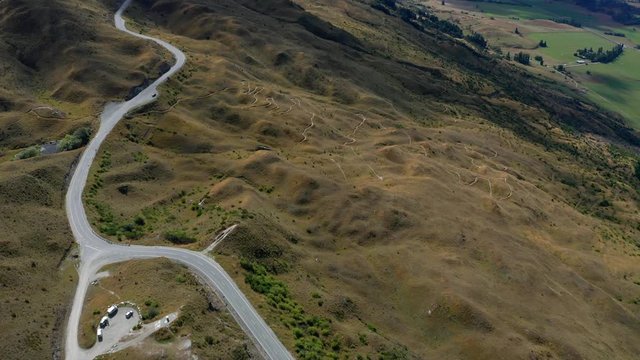 Winding road in mountains of The Coronet Peak and Skippers Road entrance. Arrowtown in the background.