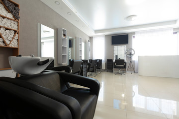 Black wash sink and armchair in salon