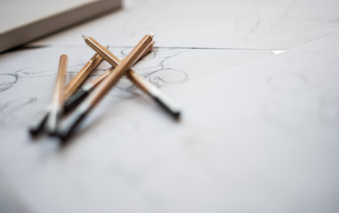 A top view flat lay of many figure drawing pencil and marker sketches. The artist worskspace with male and female drawings and pencils on the white paper, art, craft, creativity, inspiration, concepts